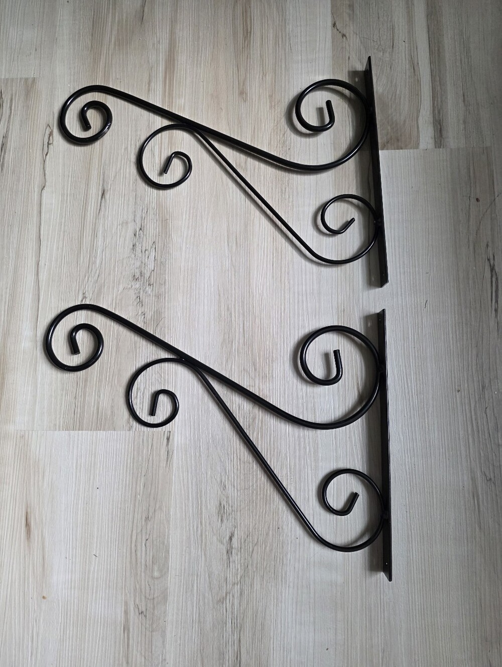 Black decorative iron wall-mounting brackets with a scroll and swirl design